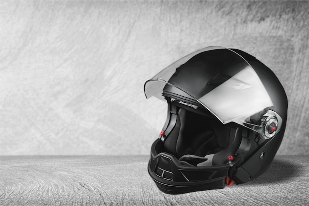 Foto casco de motociclista negro sobre fondo gris