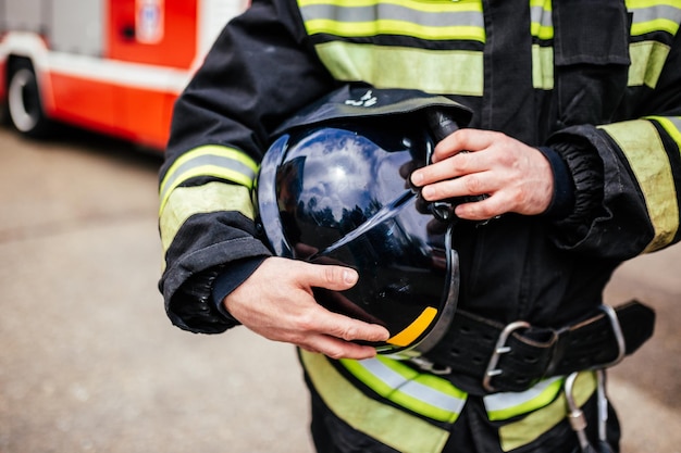 Casco negro en primer plano de mano de bombero