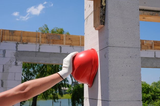 Casco de seguridad en la mano de un trabajador en un concepto de seguridad del sitio de construcción