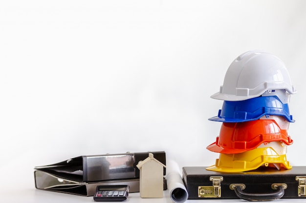 Casco de seguridad en la mesa en la oficina, concepto de ingeniero Trabajo en equipo de construcción de edificios