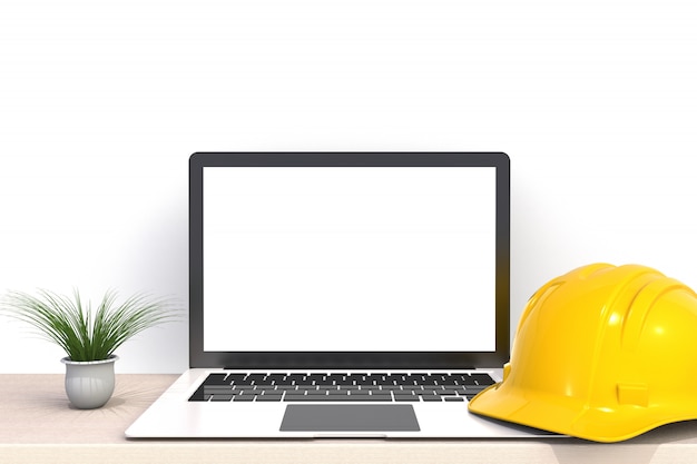 Casco de seguridad con la pantalla en blanco blanca del ordenador portátil en la vista frontal de la mesa de trabajo de madera