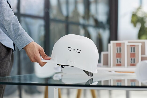 casco de seguridad y planta de arquitecto en mesa de madera