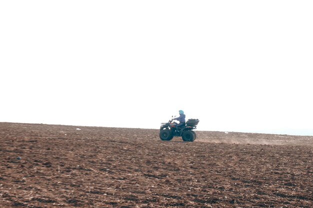 Foto casco sentado en quad atv en las montañas