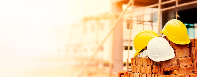 Foto cascos de ingenieros y trabajadores de la construcción en montones de ladrillos en el sitio de construcción