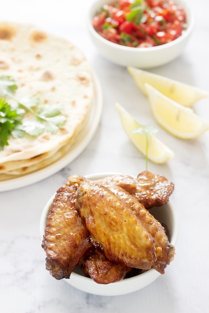 Caseira deliciosa comida de tortilhas, salsa e asas fritas.