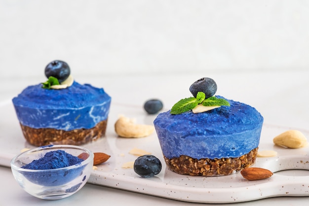 Caseiro azul mirtilo e ervilha borboleta vegan bolos de caju com frutas frescas, hortelã, nozes. conceito de comida vegetariana saudável