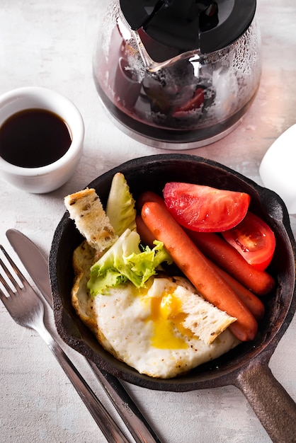 Caseiro delicioso café da manhã americano com ovo frito, torradas, salsicha, legumes, café preto