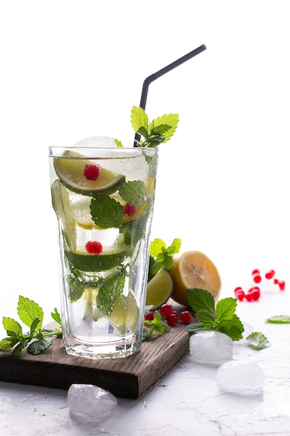 Caseiro mojito cocktail com limão, limão, folhas de hortelã, com gelo e groselha. conceito de bebida de verão.