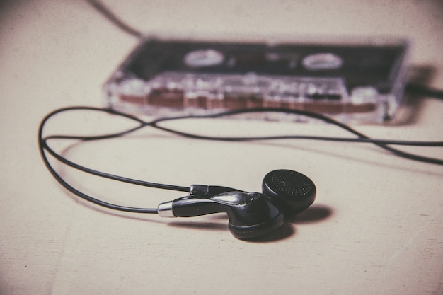 Casete de audio magnético vintage y auriculares en el piso de madera