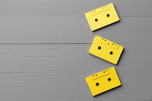 Casetes de audio amarillos sobre fondo gris vista superior, espacio de copia