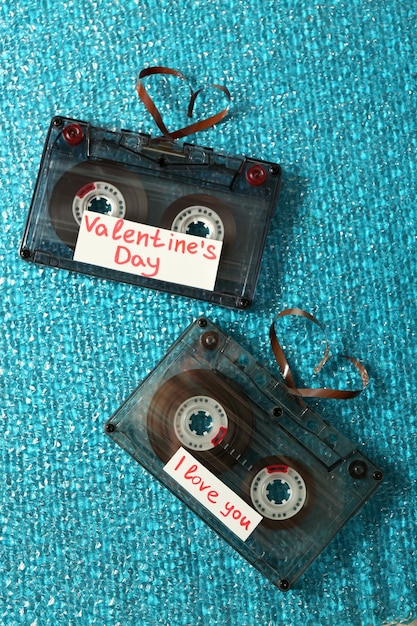 Foto casetes de audio retro con cintas en forma de corazones sobre fondo de textura azul