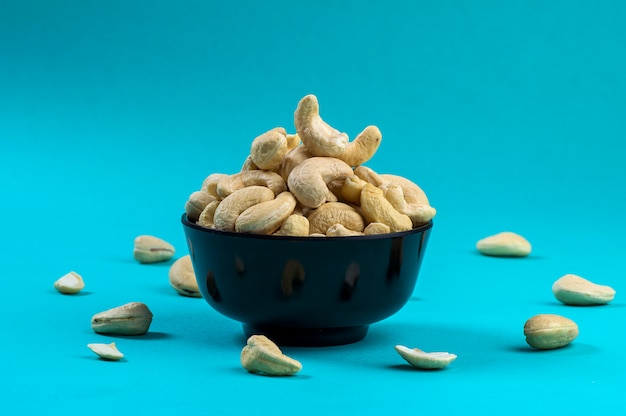 Cashewnüsse in einer Schüssel auf blauem Hintergrund