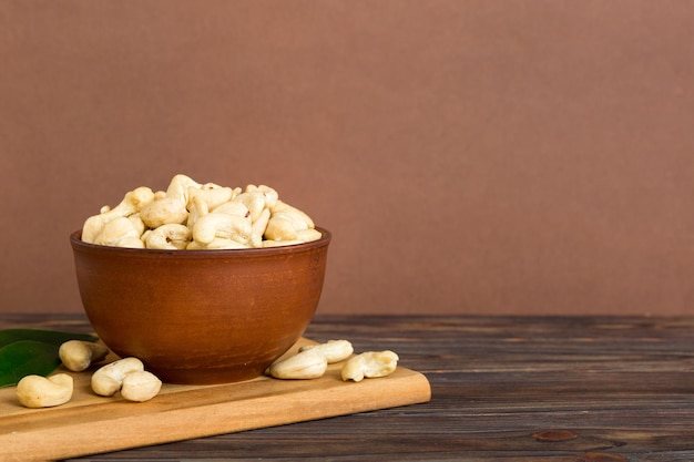 Cashewnüsse in Holzschale auf Tischhintergrund, Draufsicht, Platz für Text, gesunde Ernährung