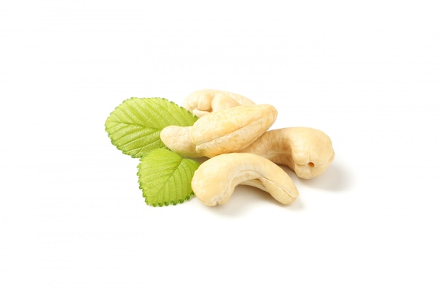 Cashewnüsse und Blätter isoliert auf Weiß