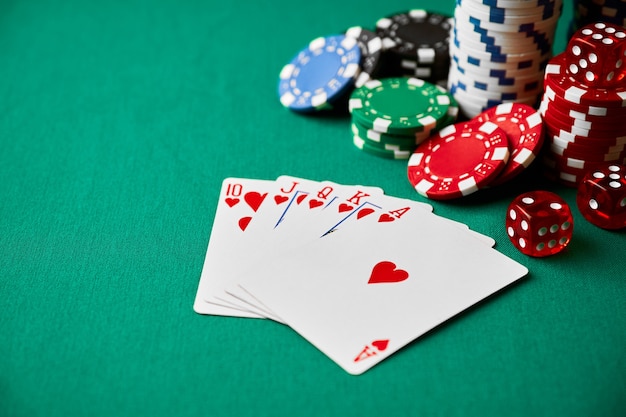 Casino-Chips Spielkarten und Würfel auf grünem Stofftisch