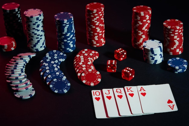 Casino-Chips und Karten auf schwarzer Tischoberfläche. Glücksspiel, Glück, Spiel und Unterhaltungskonzept - Nahaufnahme. Online-Poker. Platz kopieren. Ideal für Werbung. Stillleben