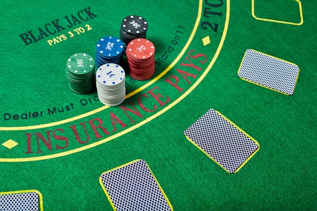 Casino-Chips und Kartenspiel auf grünem Casino-Tisch, Pokerspielkonzept, Draufsicht.