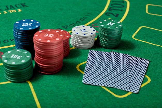 Casino-Chips und Kartenspiel auf grünem Casino-Tisch, Pokerspielkonzept, Draufsicht.