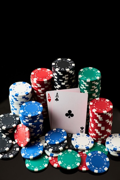 Casino-Chips und Spielkarten auf dunklem reflektierenden Hintergrund