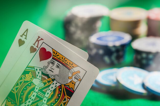 Casino-Glücksspielkonzept Ass- und Königsherzen und Pokerchips auf grünem Filz