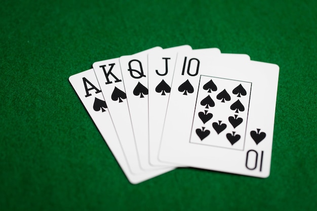 Foto casino, juego de azar, juegos de suerte, riesgo y concepto de entretenimiento - poker de color real mano de cartas en tela verde