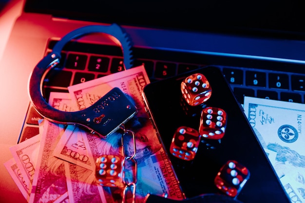 Casino online e conceito de lei jogando smartphone de dados e algemas no teclado em luz neon