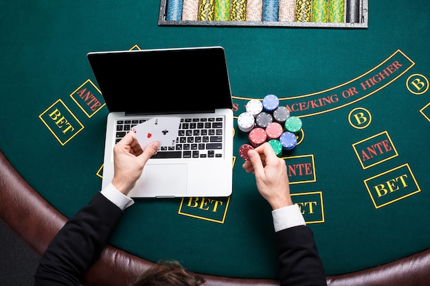 Casino, Online-Glücksspiel, Technologie und Menschenkonzept - Nahaufnahme eines Pokerspielers mit Spielkarten