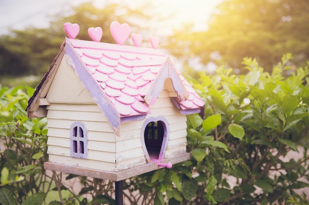 Casita para pájaros antigua casa de pájaros encantadora de madera en el jardín con sol de la mañana tono de color vintage