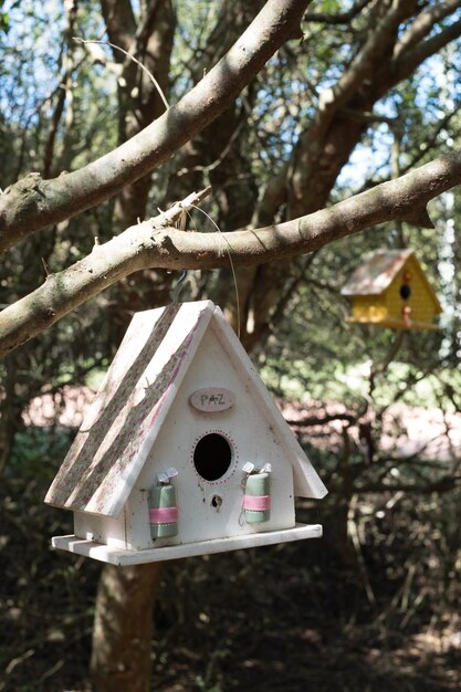 Una casita para pájaros con una etiqueta rosa que dice "la casita para pájaros"