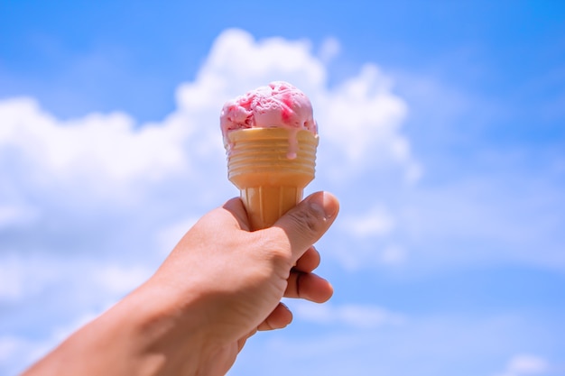 Casquinha de sorvete realizada até o céu quente de verão