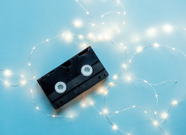 Cassete VHS dos anos 80 com luzes de fada em fundo azul