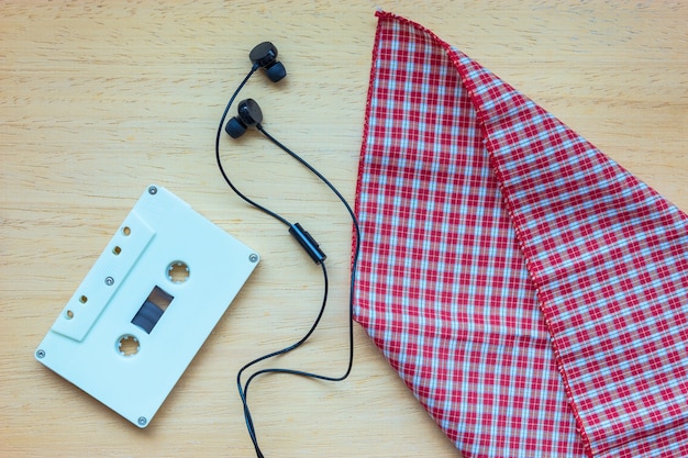 Cassette, auriculares y cuaderno en blanco en la madera