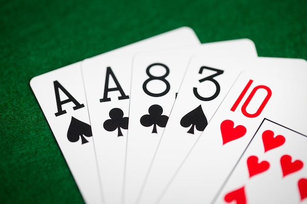 cassino, jogos de azar, jogos de azar, perigo e conceito de entretenimento - mão de pôquer de cartas de baralho em pano verde