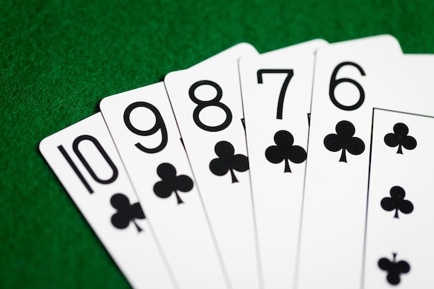 cassino, jogos de azar, jogos de azar, perigo e conceito de entretenimento - mão de pôquer reta de cartas de baralho em pano verde