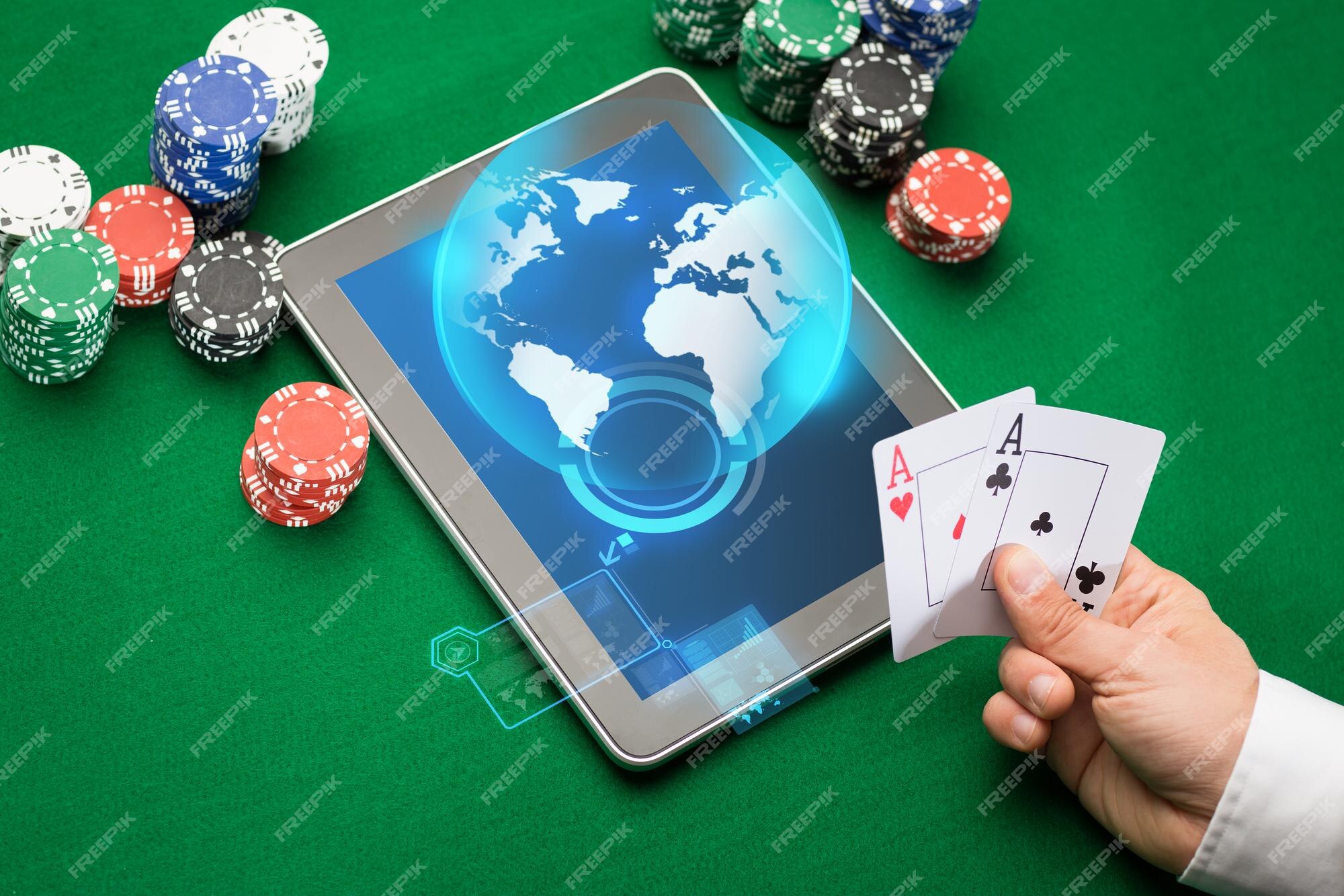 Cassino online, jogos de azar em todo o mundo, tecnologia e conceito de  pessoas - close-up do jogador de pôquer com cartas de baralho, computador  tablet pc e fichas na mesa de cassino verde