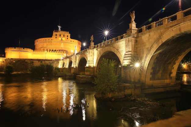 Castel St. Angelo y St. Angelo Bridge en la noche Roma, Italia