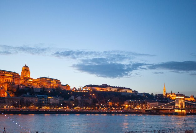 Castelo de Budapeste ao pôr do sol dos marcos húngaros do rio Danúbio