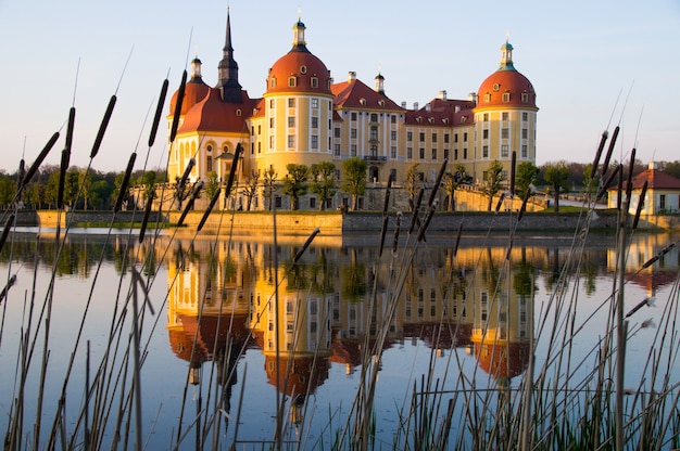 Castelo de moritzburg refletido na água ao pôr do sol na saxônia, alemanha