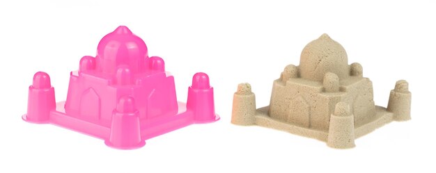 Castelo de plástico e escultura de areia isolada em um fundo branco