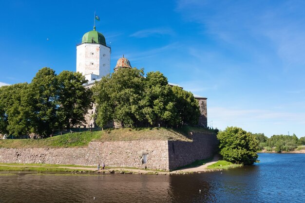 Castelo de Vyborg entre árvores verdes em dia ensolarado no Golfo da Finlândia Famosa fortaleza medieval
