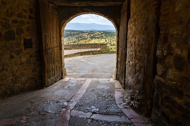 Castelo Pedraza em Segóvia. Antigo palácio medieval dos cavaleiros feito de pedra. Fortaleza com ruas interiores de pedra, plantas verdes, arcos e túneis. Espanha.