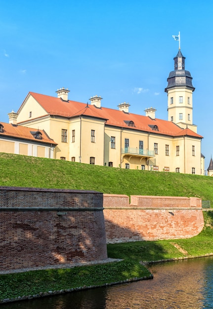 Castelo restaurado antigo com um fosso na cidade de Nesvizh.