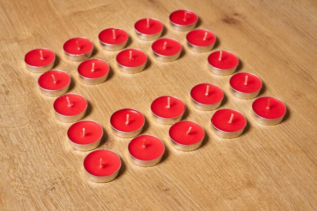 Castiçal em forma de coração com velas vermelhas no centro.