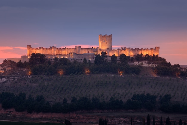 Castillo de peafiel na província de valladolid iluminado ao pôr do sol visto de longe luz dourada