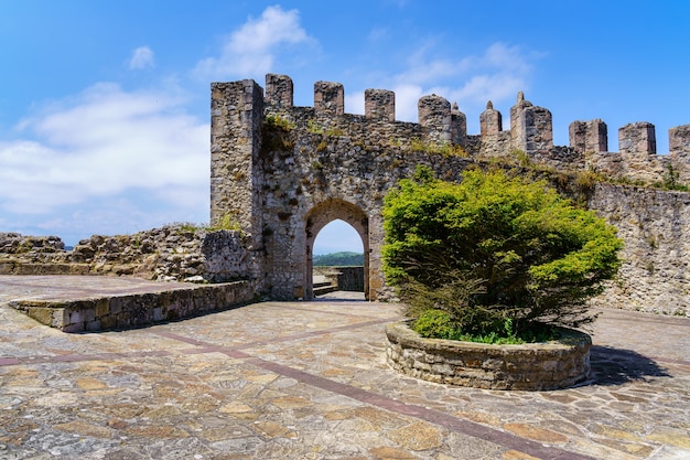 Castillo medieval con muro de piedra y puerta de entrada arqueada en día soleado