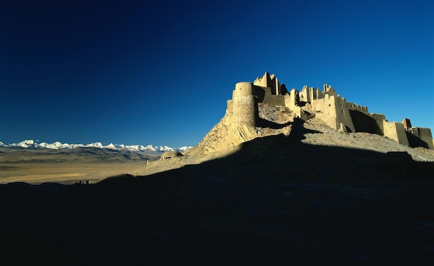 Foto un castillo está en una montaña con una montaña en el fondo