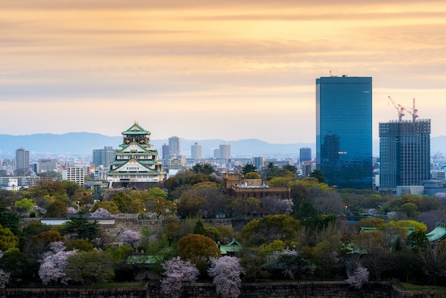 Castillo de Osaka con flor de cerezo y distrito comercial del centro en Japón