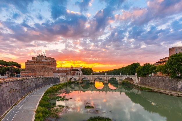 Castillo de San Ángel y puente con reflejo de espejo en el río Tíber durante el hermoso amanecer en Roma, Italia.