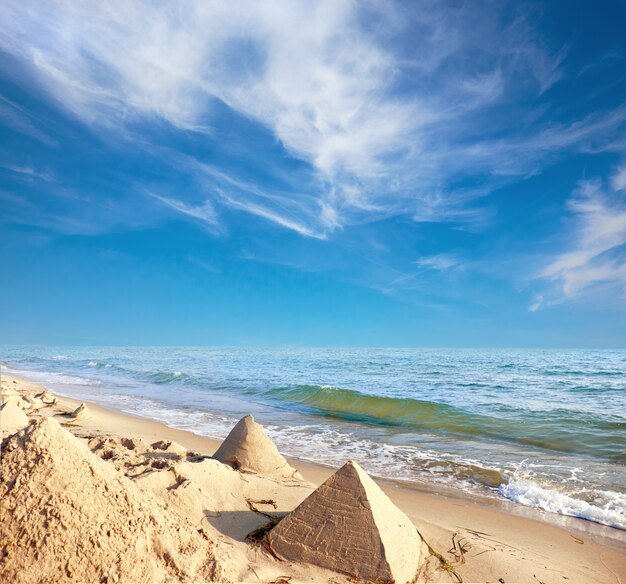 Castillos de arena en forma de pirámides en una playa