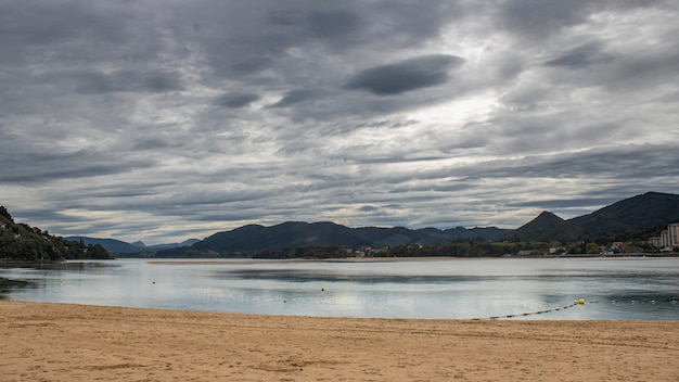 Castro Urdiales encalha em um dia com nuvens cinzentas.